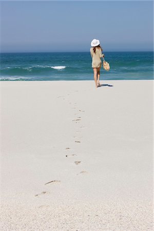 simsearch:6108-05864591,k - Rear view of a woman walking on the beach Stock Photo - Premium Royalty-Free, Code: 6108-05866575