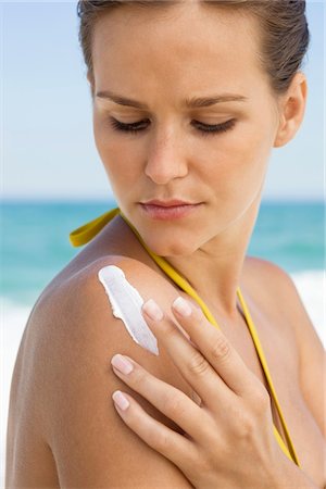 shoulder (anatomy) - Woman applying suntan lotion on her shoulder Foto de stock - Sin royalties Premium, Código: 6108-05866590