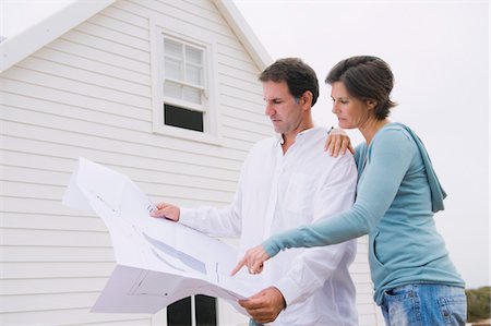 Couple looking at a blueprint of a house Stock Photo - Premium Royalty-Free, Code: 6108-05866753