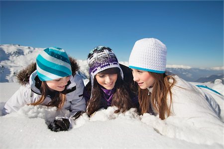 sisters snow - Three teenage girls in ski clothes, lying in snow Stock Photo - Premium Royalty-Free, Code: 6108-05866952