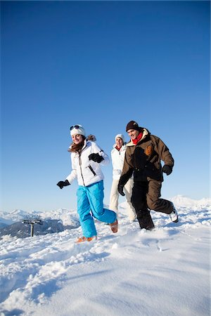 simsearch:6108-05867178,k - Couple and daughter in ski wear running in snow Fotografie stock - Premium Royalty-Free, Codice: 6108-05866974