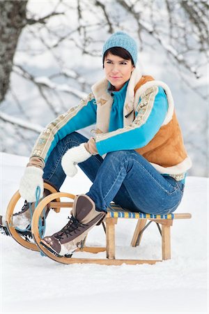 simsearch:6108-05867115,k - Young woman sitting on sled Foto de stock - Royalty Free Premium, Número: 6108-05867074
