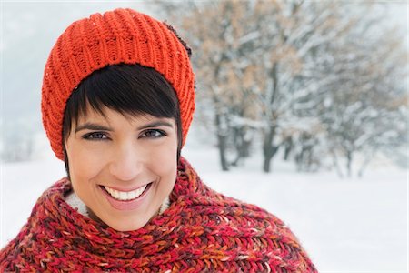 Young woman in winter clothes smiling at camera Stock Photo - Premium Royalty-Free, Code: 6108-05867087