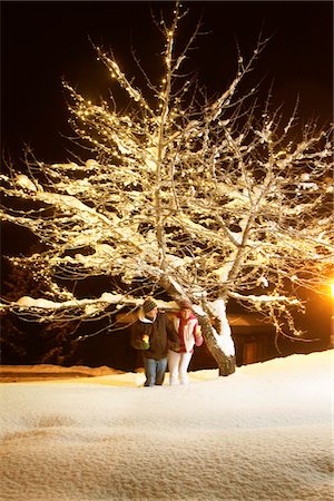 people night illuminated outdoors - Young couple holding candles, walking in snow by night Stock Photo - Premium Royalty-Free, Code: 6108-05867024