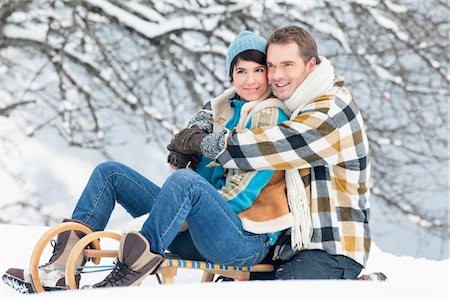 simsearch:6108-05867016,k - Young couple embracing on sled Fotografie stock - Premium Royalty-Free, Codice: 6108-05867035