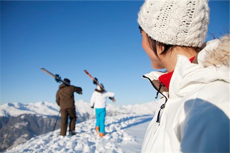 simsearch:6108-05867178,k - Woman looking at father and daughter carrying skis Fotografie stock - Premium Royalty-Free, Codice: 6108-05867159