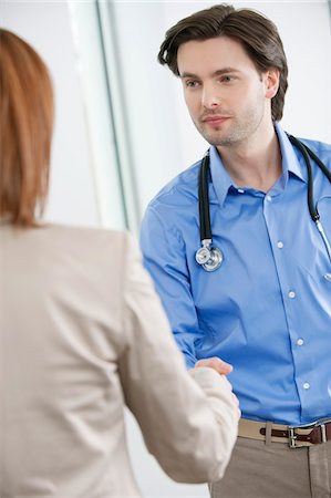 doctor, standing, back - Doctor shaking hand with a woman Stock Photo - Premium Royalty-Free, Code: 6108-05867279