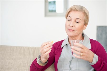 Woman taking a capsule Stock Photo - Premium Royalty-Free, Code: 6108-05867290