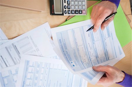 file - Man's hands filling his tax form Stock Photo - Premium Royalty-Free, Code: 6108-05867346