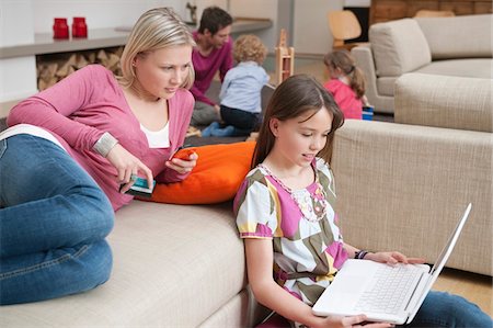 Woman assisting her daughter in using a laptop Stock Photo - Premium Royalty-Free, Code: 6108-05867397
