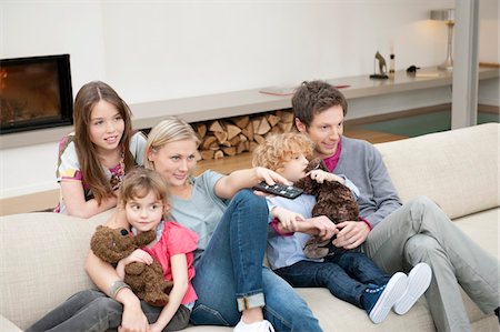 family in a living room fireplace - Family watching television Stock Photo - Premium Royalty-Free, Code: 6108-05867399