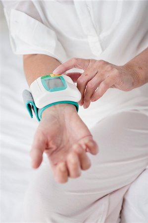 Woman checking her blood pressure Stock Photo - Premium Royalty-Free, Code: 6108-05867307