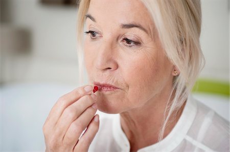 pillbox - Woman taking a capsule Stock Photo - Premium Royalty-Free, Code: 6108-05867306