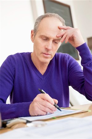 Man filling his tax form Stock Photo - Premium Royalty-Free, Code: 6108-05867314