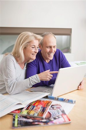 surfing the net - Couple à la recherche à un ordinateur portable et souriant Photographie de stock - Premium Libres de Droits, Code: 6108-05867315