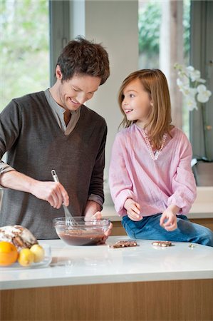 En remuant le mélange dans un bol avec sa fille de l'homme Photographie de stock - Premium Libres de Droits, Code: 6108-05867486