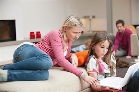 Woman assisting her daughter in using a laptop Stock Photo - Premium Royalty-Free, Code: 6108-05867403
