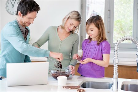 Family cooking with the recipe on a laptop Stock Photo - Premium Royalty-Free, Code: 6108-05867406