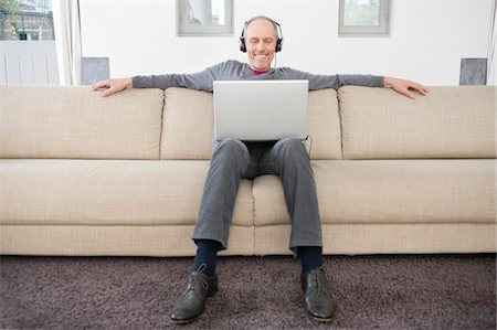 simsearch:6108-08725387,k - Man using a laptop and listening to music Stock Photo - Premium Royalty-Free, Code: 6108-05867426