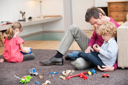 sister with toys - Man playing with his son in a living room Stock Photo - Premium Royalty-Free, Code: 6108-05867503