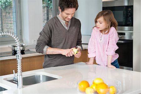 Man preparing breakfast with his daughter standing with him Stock Photo - Premium Royalty-Free, Code: 6108-05867538