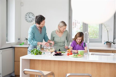 simsearch:6108-05871804,k - Family preparing food in the kitchen Foto de stock - Sin royalties Premium, Código: 6108-05867662