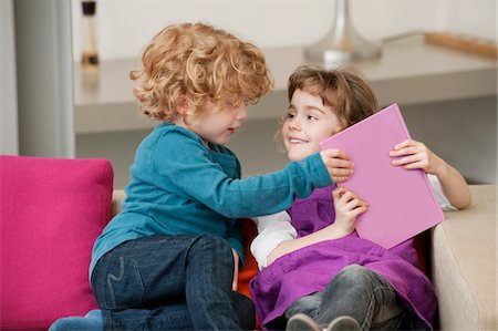 simsearch:632-08227559,k - Boy sitting on a couch with his sister Stock Photo - Premium Royalty-Free, Code: 6108-05867669