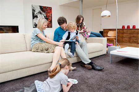 people sitting on a sofa - Family in a living room Stock Photo - Premium Royalty-Free, Code: 6108-05867691