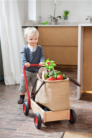 Boy pushing a cart with a vegetable bag on it Foto de stock - Sin royalties Premium, Código: 6108-05867610