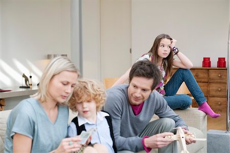 family sitting inside plane - Family in a living room Stock Photo - Premium Royalty-Free, Code: 6108-05867707