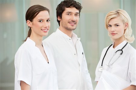 simsearch:6108-05868030,k - Portrait of three doctors smiling Fotografie stock - Premium Royalty-Free, Codice: 6108-05867933
