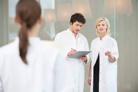 doctor, standing, back - Doctor discussing with her colleague Stock Photo - Premium Royalty-Free, Code: 6108-05867936