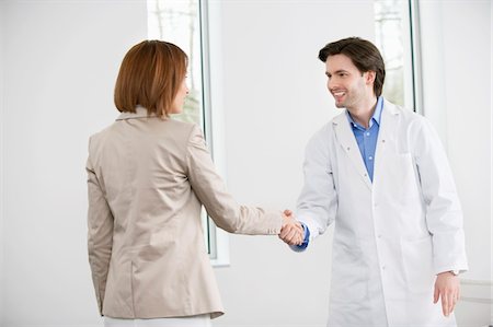 doctor office happy - Doctor shaking hand with a woman Stock Photo - Premium Royalty-Free, Code: 6108-05868058