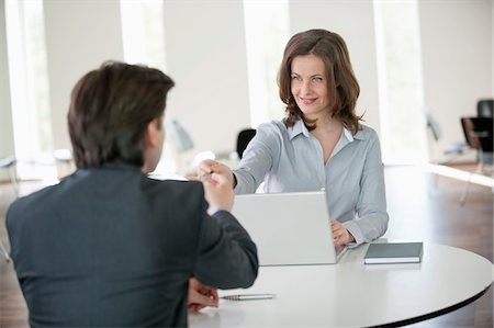 people giving cards - Businesswoman giving a credit card to a businessman Stock Photo - Premium Royalty-Free, Code: 6108-05868060