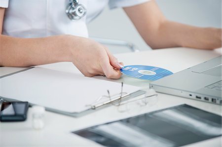 Femme médecin insérer le CD dans un ordinateur portable Photographie de stock - Premium Libres de Droits, Code: 6108-05868000