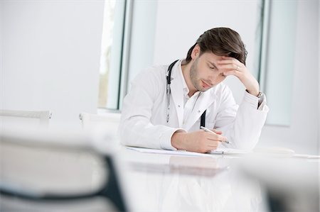 Male doctor sitting in his office and looking upset Stock Photo - Premium Royalty-Free, Code: 6108-05868034