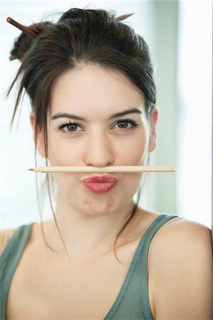 Femme équilibrage un crayon sur la lèvre Photographie de stock - Premium Libres de Droits, Code: 6108-05868247