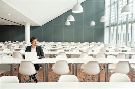 Businessman sitting at a cafeteria and using a laptop Foto de stock - Sin royalties Premium, Código: 6108-05868374