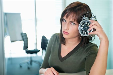 Portrait of a businesswoman holding an alarm clock Stock Photo - Premium Royalty-Free, Code: 6108-05868320