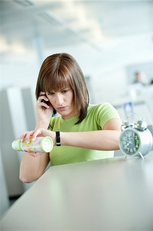 Businesswoman talking on a mobile phone and checking the time Stock Photo - Premium Royalty-Free, Code: 6108-05868322