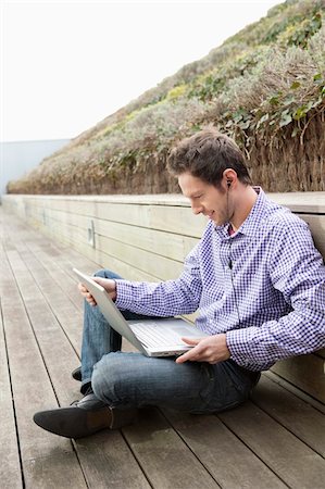 Man using a laptop and listening to music Foto de stock - Sin royalties Premium, Código: 6108-05868401