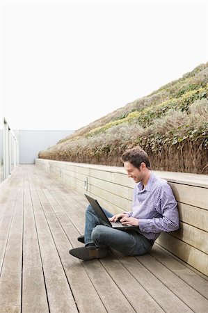 strandpromenade - Man using a laptop on a boardwalk Foto de stock - Sin royalties Premium, Código: 6108-05868424