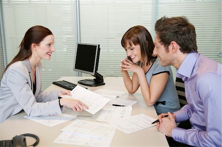 Female real estate agent showing a brochure to a couple Stock Photo - Premium Royalty-Free, Code: 6108-05868668