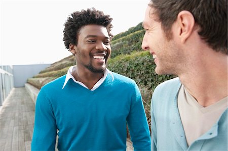 Friends discussing on a boardwalk Stock Photo - Premium Royalty-Free, Code: 6108-05868606