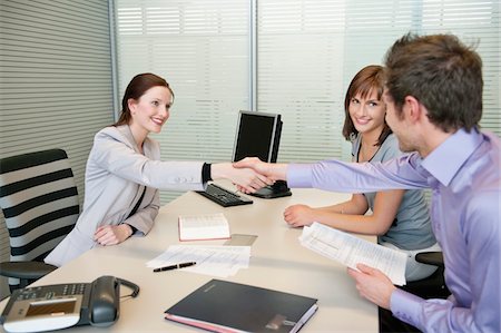 Female real estate agent shaking hands with a couple Fotografie stock - Premium Royalty-Free, Codice: 6108-05868615