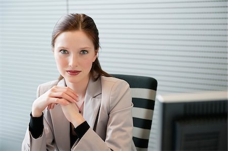 Businesswoman sitting in an office Stock Photo - Premium Royalty-Free, Code: 6108-05868621