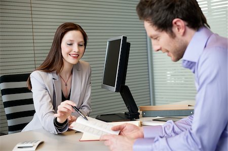 Female real estate agent showing a brochure to a man Foto de stock - Sin royalties Premium, Código: 6108-05868637