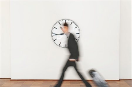 photo clock - Businessman carrying his luggage Stock Photo - Premium Royalty-Free, Code: 6108-05868771