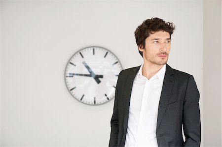 Businessman standing in front of a clock Stock Photo - Premium Royalty-Free, Code: 6108-05868798