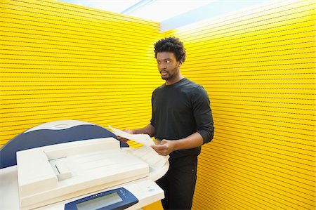 Businessman using a photocopy machine in an office Stock Photo - Premium Royalty-Free, Code: 6108-05868724